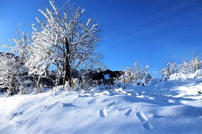 Snow on field against clear blue sky