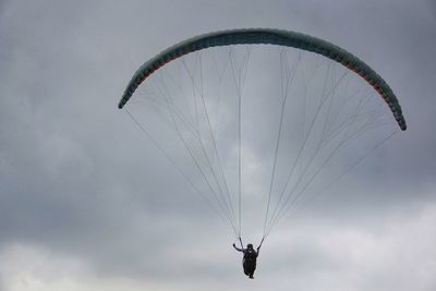 Low angle view of person paragliding against sky