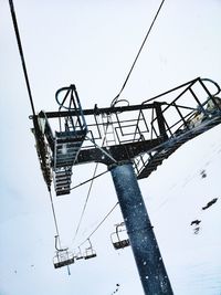 Low angle view of crane against sky during winter