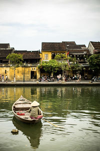 Boats in lake against buildings in city