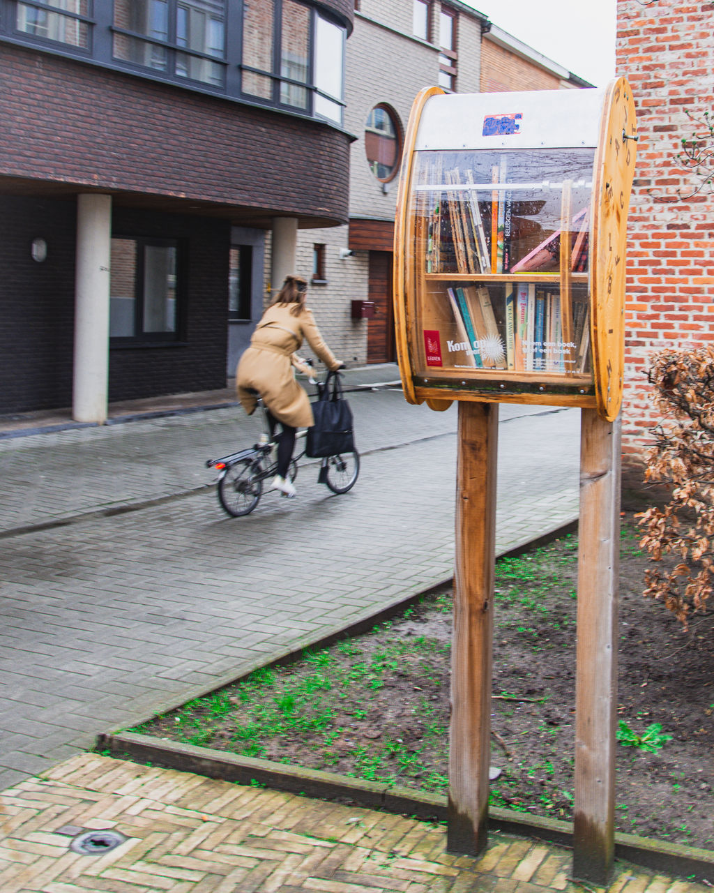 MAN RIDING BICYCLE BY BUILDING