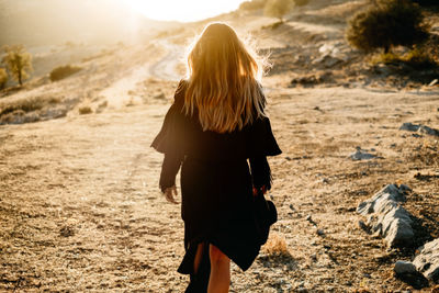 Rear view of woman walking on beach