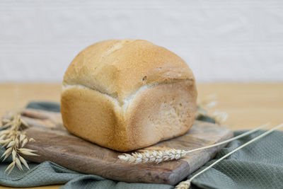 One white round bread with wheat fiber on the table.