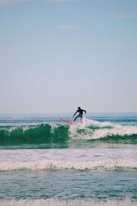 Man surfing on sea against clear sky