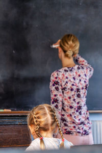 Rear view of girl with arms raised