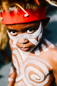 Close-up portrait of shirtless boy with body paint