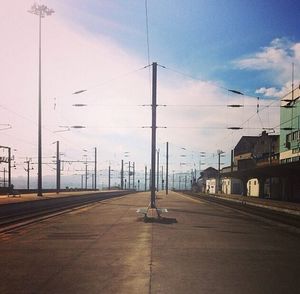 Empty road against cloudy sky