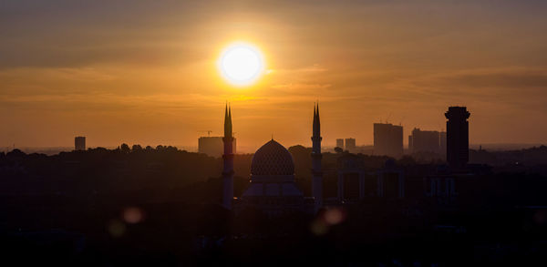 Silhouette buildings against sky during sunset