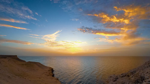 Sunset over atlantic ocean seen from rocky coastline, mauritania