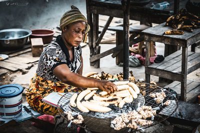 Woman preparing food at market stall