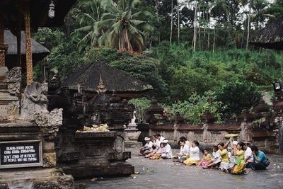 Group of people sitting outside temple against building
