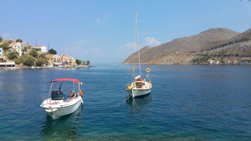 Boats sailing in sea against sky