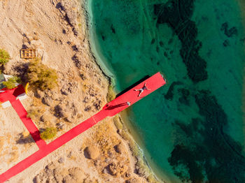 Aerial view of friends on red jetty at beach