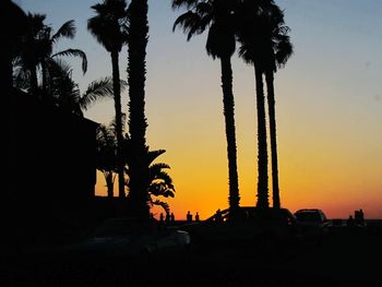 Silhouette palm trees against sky during sunset