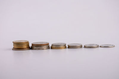 Close-up of coins on table against white background