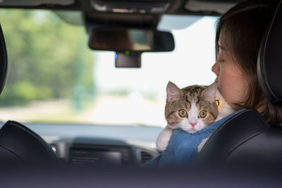 Asian woman drive car for travel roadtrip with her cat