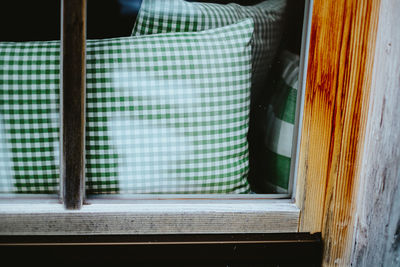 Close-up of pillow behind window