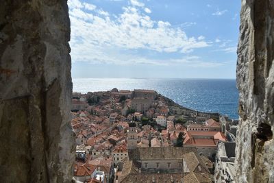 High angle view of townscape by sea against sky