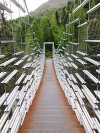 Empty footbridge amidst plants and railing