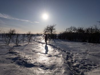 Scenic view of snow covered field against sky