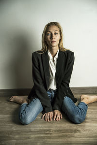 Portrait of young woman sitting on floor at home