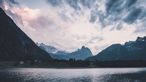 Scenic view of lake by mountains against sky