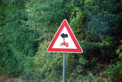 Road sign against trees