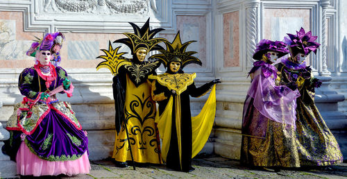 Portrait of people dressed up for carnival against wall