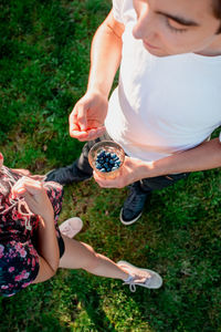 High angle view of couple holding hands on field