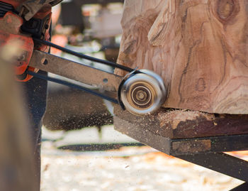 Cropped image of man using equipment on wooden sculpture