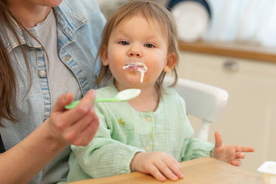 Cropped hands of boy eating food at home