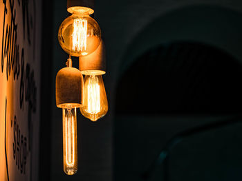 Close-up of illuminated light bulbs against wall