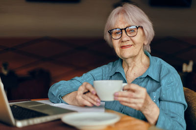 Portrait of senior businesswoman drinking coffee at cafe