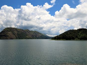 Scenic view of lake by mountains against sky