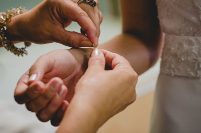 Close-up of hand dressing bride