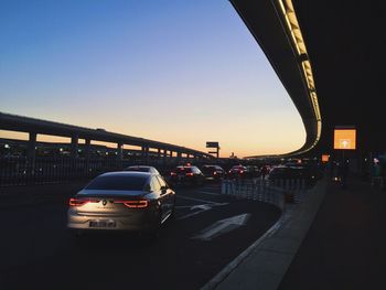 Cars on road in city against clear sky