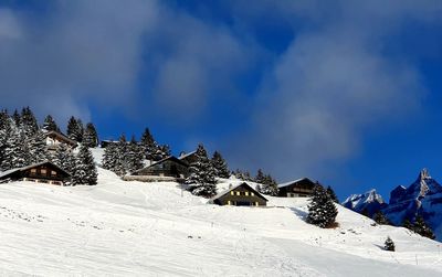 Snow covered land and mountains against sky