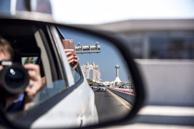 Portrait of man photographing through car windshield