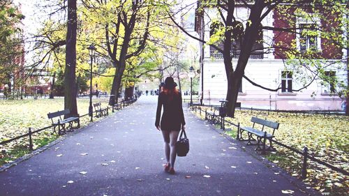 Rear view of woman walking on footpath