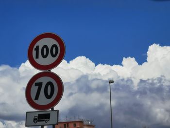 Low angle view of road sign against sky