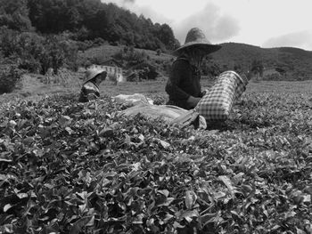 People sitting on field by mountain