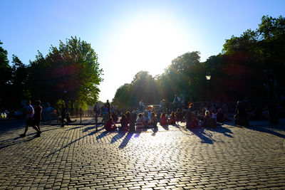 People on sidewalk against clear sky