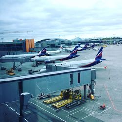 Boats moored at airport against sky