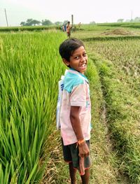 Full length of smiling girl standing on field