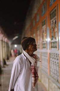 Midsection of man standing against building in city