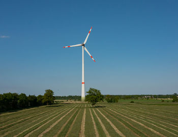 Windmill on field against clear sky