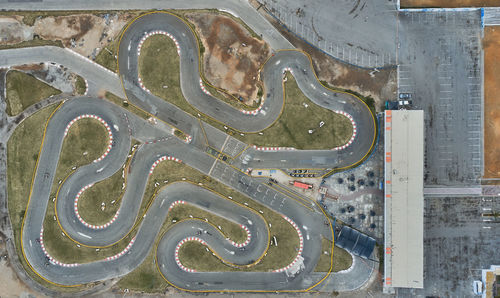 Aerial top view of the go-kart track from the drone. kart racers drive on the open track.