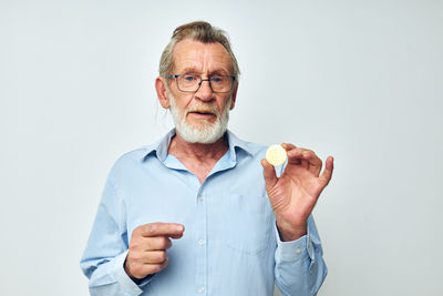 Portrait of young man holding globe against white background