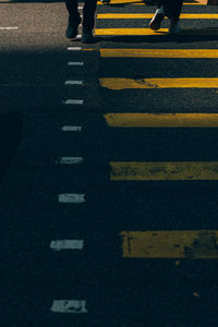 Low section of man walking on road