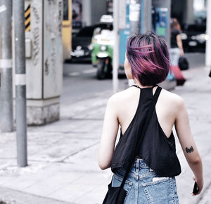 Rear view of woman standing on road